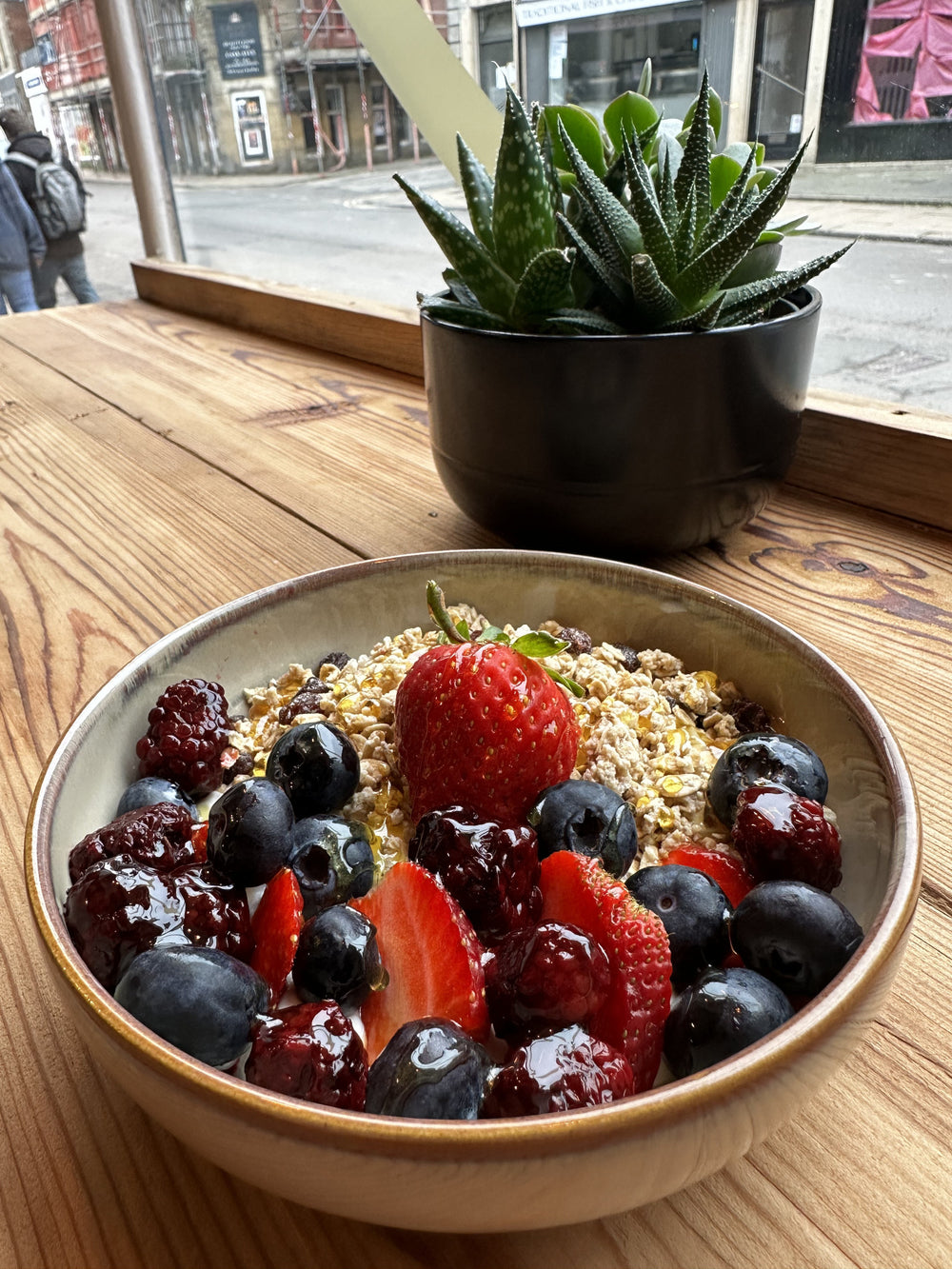 A fruit and granola bowl topped with strawberries, blueberries and berries at BALANCE
