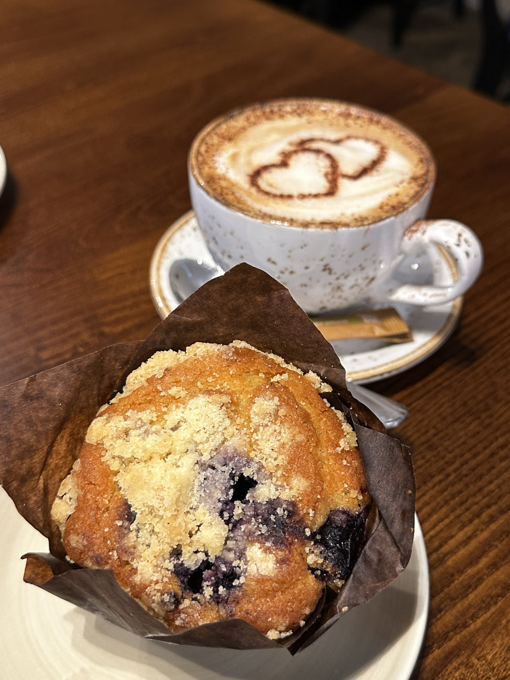 A muffin and coffee served at an indoor BALANCE table