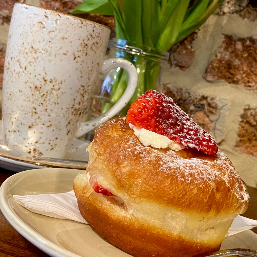 Strawberry and cream doughnut with a hot drink