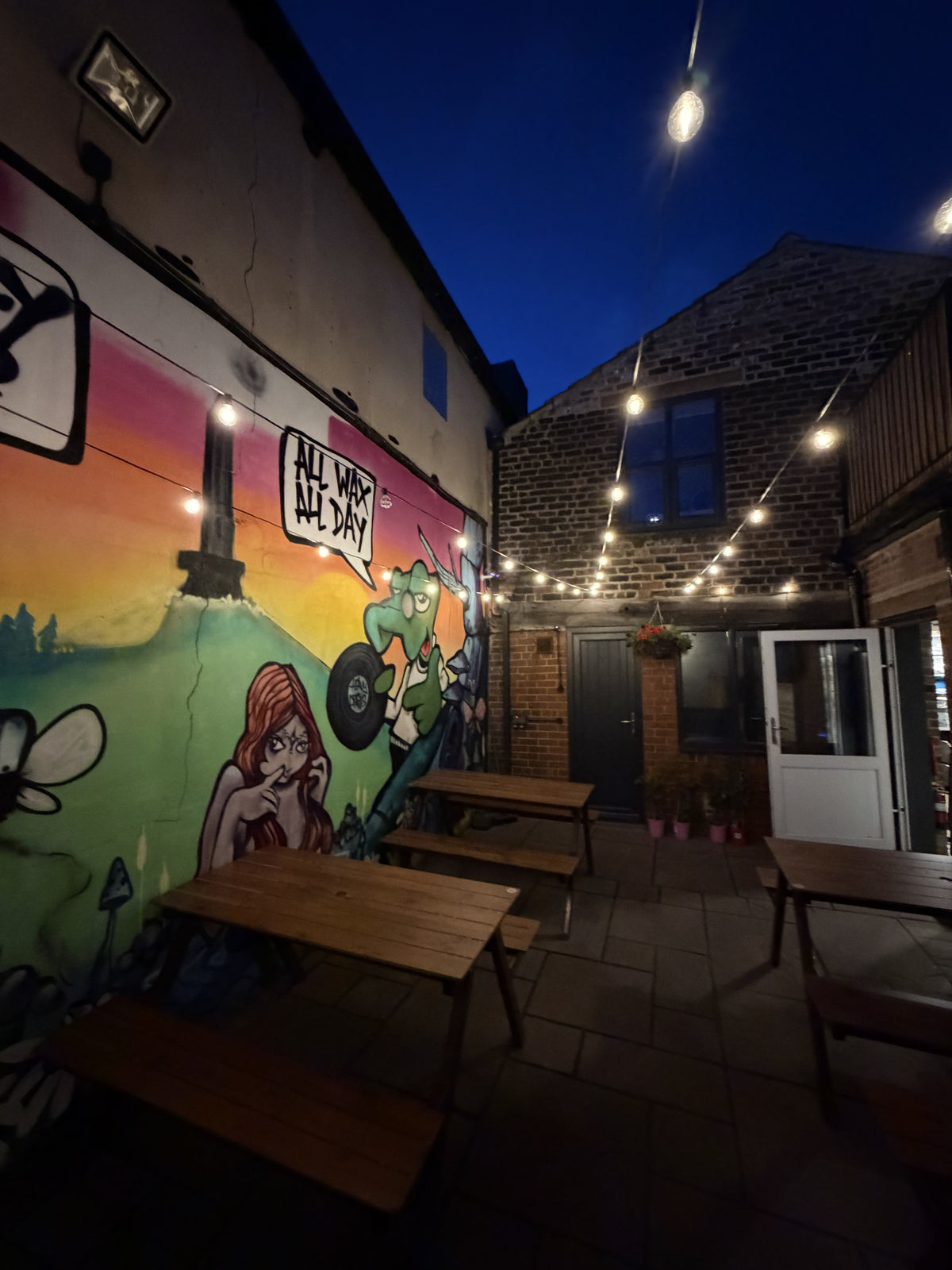 BALANCE outdoor seating area with festoon lights glowing in the evening